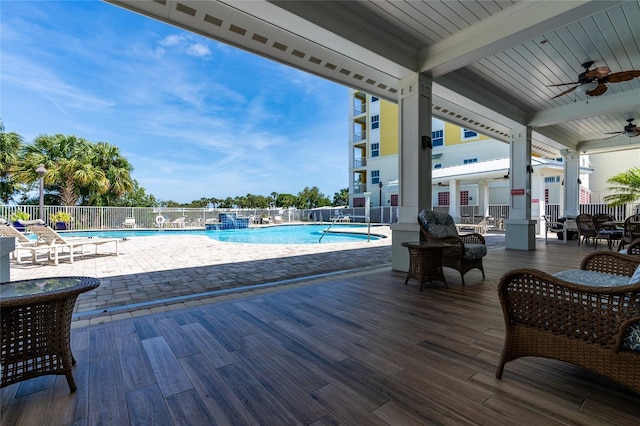 view of swimming pool featuring ceiling fan and a patio area