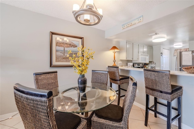 tiled dining area featuring a textured ceiling