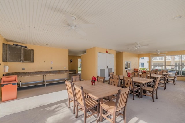 carpeted dining room with ceiling fan