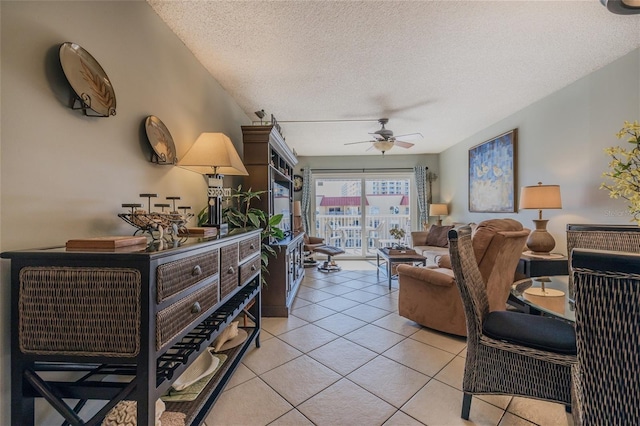 living room featuring ceiling fan, light tile patterned floors, and a textured ceiling