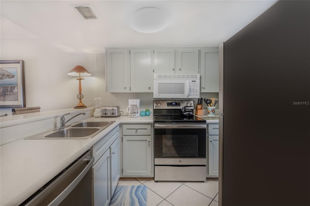 kitchen featuring appliances with stainless steel finishes, light tile patterned floors, and sink