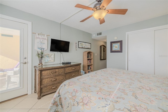 tiled bedroom with ceiling fan and a closet