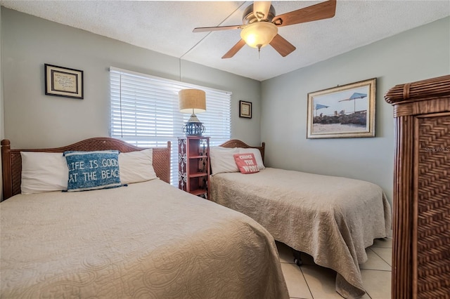 tiled bedroom with ceiling fan and a textured ceiling