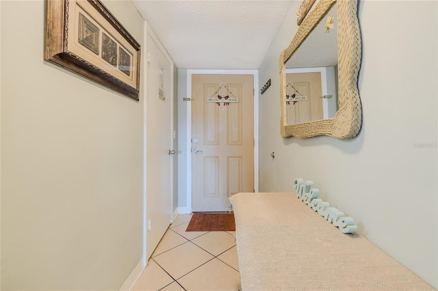 entryway featuring light tile patterned floors and a textured ceiling