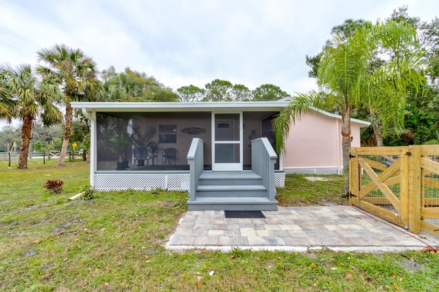 view of front of property featuring a sunroom and a front lawn