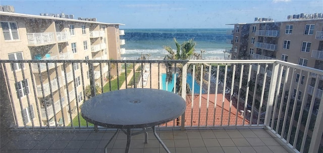 balcony with a water view and a beach view