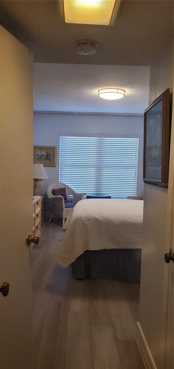 unfurnished bedroom with wood-type flooring and a textured ceiling