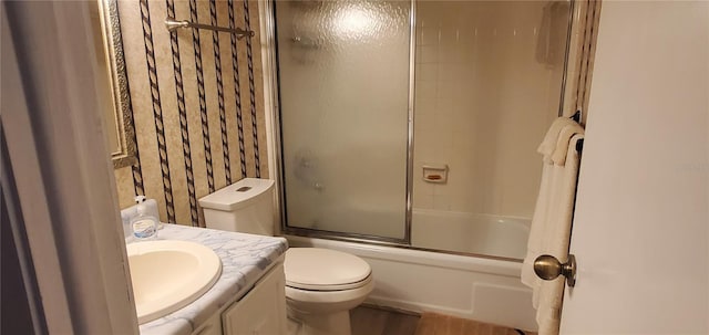 full bathroom featuring vanity, toilet, and shower / bath combination with glass door