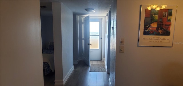 hallway featuring dark hardwood / wood-style flooring and a textured ceiling