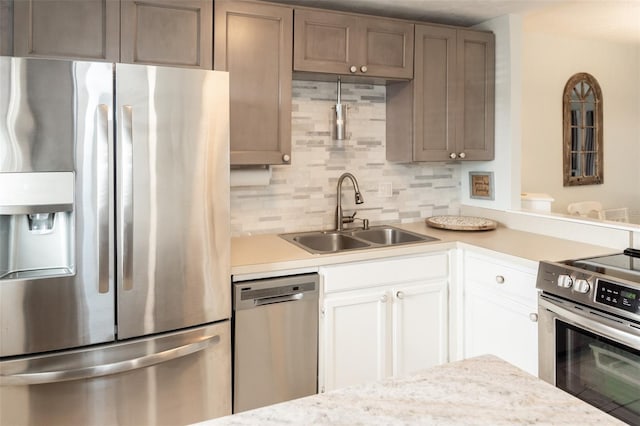 kitchen with sink, white cabinetry, stainless steel appliances, and tasteful backsplash