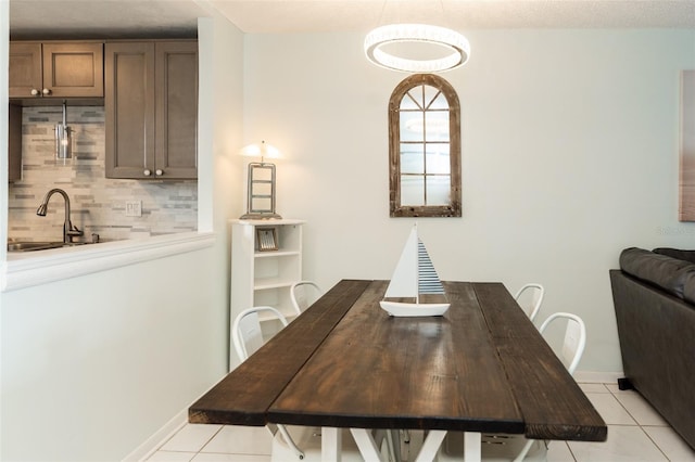 dining area featuring sink and light tile patterned floors