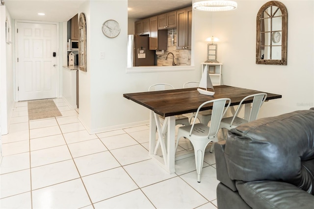 dining space featuring sink and light tile patterned floors