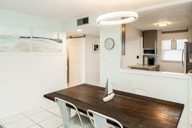 tiled dining room with a barn door