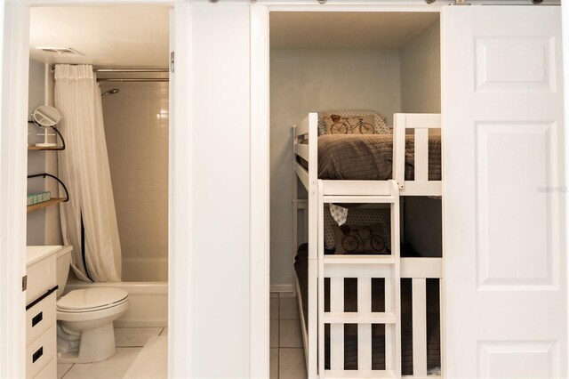 bathroom featuring tile patterned floors, toilet, and shower / tub combo