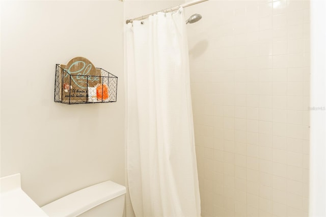 bathroom featuring a shower with shower curtain and toilet