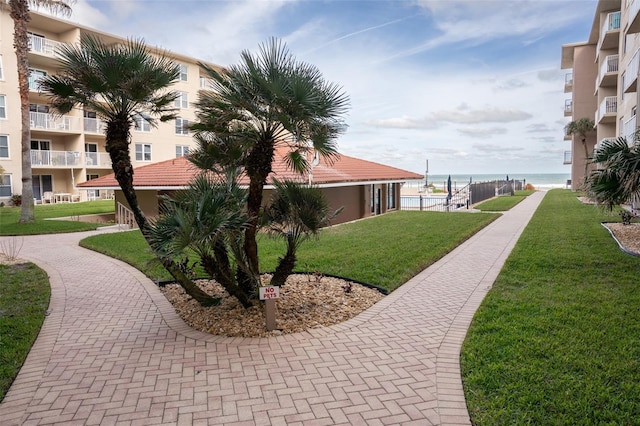 view of community featuring a lawn and a water view