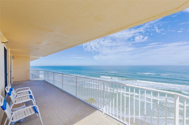 balcony featuring a beach view and a water view