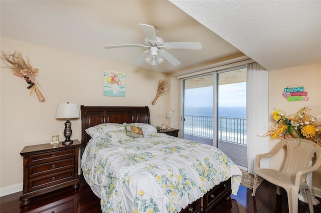 bedroom featuring dark hardwood / wood-style flooring, ceiling fan, access to outside, and a water view