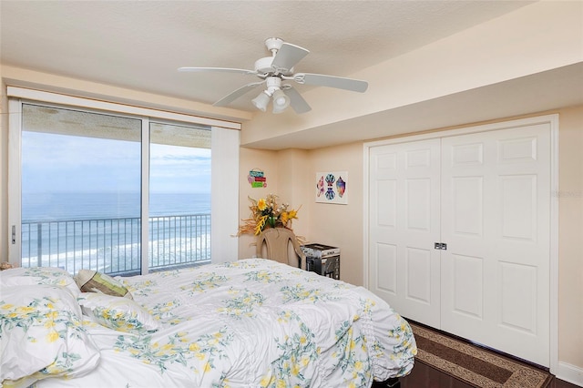 bedroom featuring a closet, ceiling fan, access to outside, and a water view