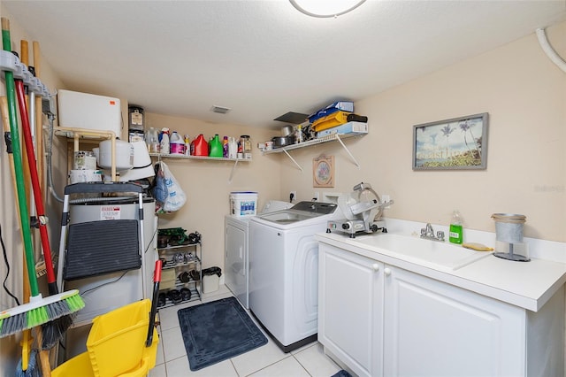 laundry room with independent washer and dryer, a textured ceiling, light tile patterned floors, cabinets, and sink