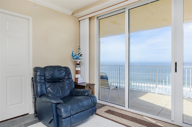 living area with crown molding and a water view