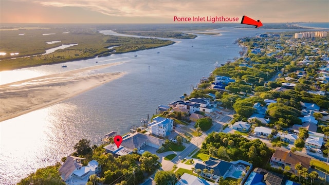 aerial view at dusk with a beach view and a water view