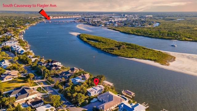 aerial view at dusk featuring a water view