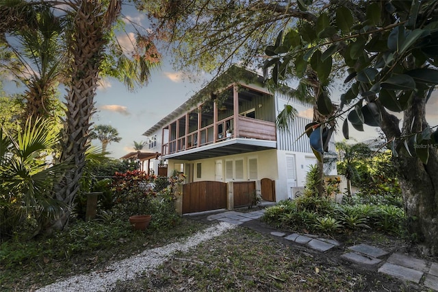 back house at dusk featuring a balcony