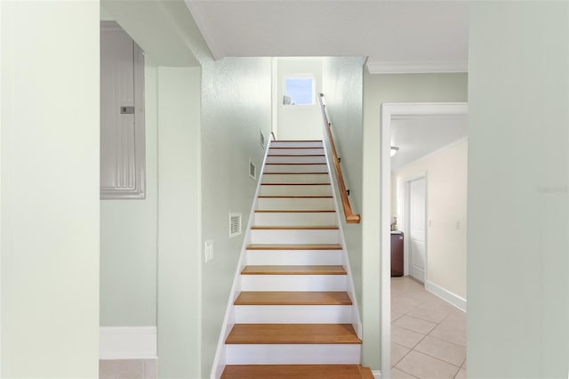 stairs featuring electric panel, tile patterned floors, and crown molding