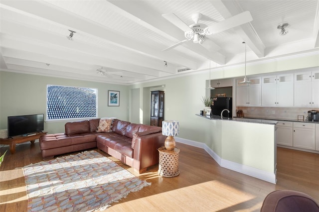 living room with beam ceiling and light hardwood / wood-style flooring