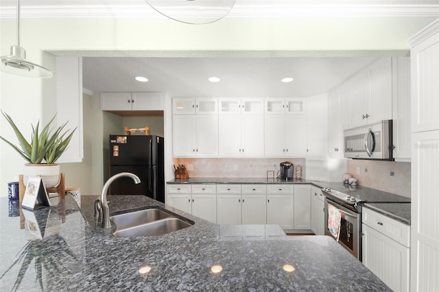 kitchen with dark stone countertops, white cabinetry, sink, and appliances with stainless steel finishes