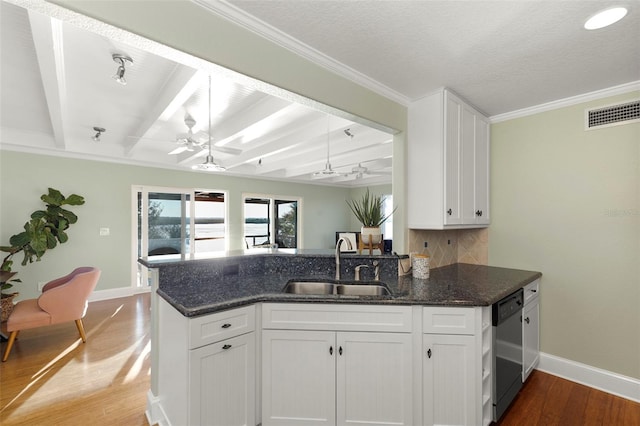 kitchen with dark stone counters, dishwasher, beamed ceiling, white cabinets, and hardwood / wood-style floors