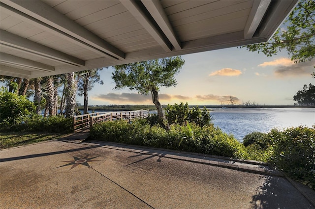 patio terrace at dusk featuring a water view