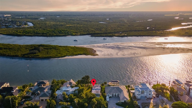 aerial view at dusk featuring a water view