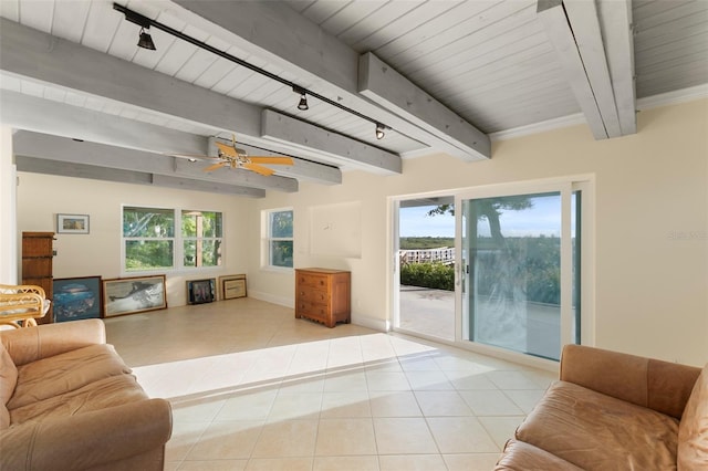 living area with tile patterned floors, beamed ceiling, track lighting, and a ceiling fan