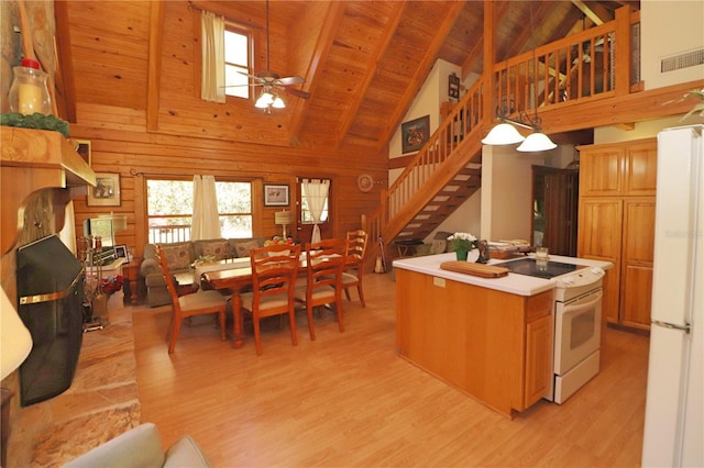 kitchen featuring pendant lighting, wood walls, white appliances, and high vaulted ceiling