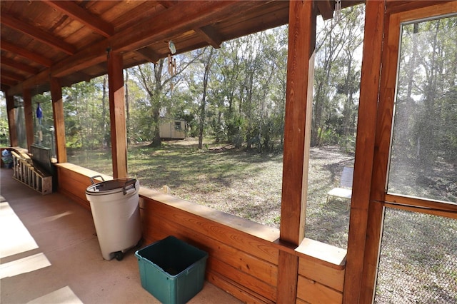 unfurnished sunroom featuring beamed ceiling and wooden ceiling