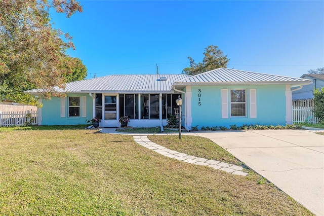 ranch-style home with a sunroom and a front lawn