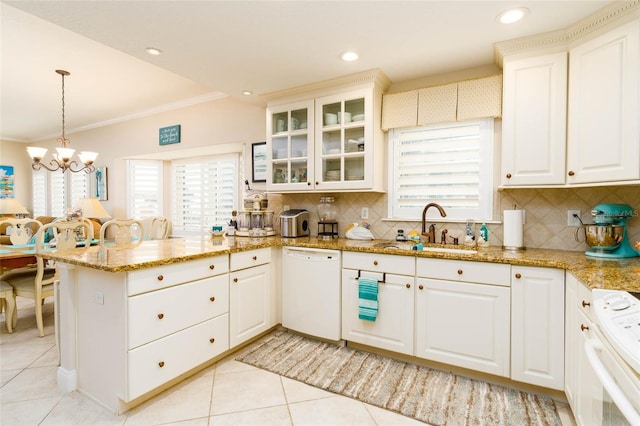 kitchen with decorative backsplash, white appliances, sink, a chandelier, and hanging light fixtures