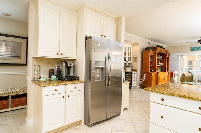 kitchen with white cabinets, stainless steel fridge with ice dispenser, light stone counters, and ceiling fan