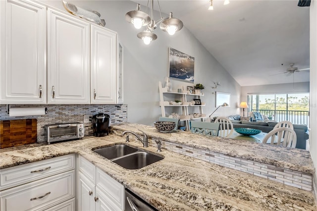 kitchen featuring white cabinets, sink, vaulted ceiling, ceiling fan, and tasteful backsplash