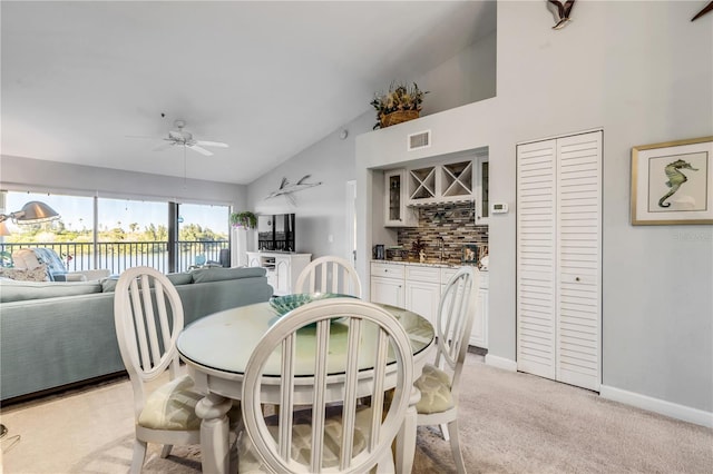 carpeted dining area featuring vaulted ceiling and ceiling fan