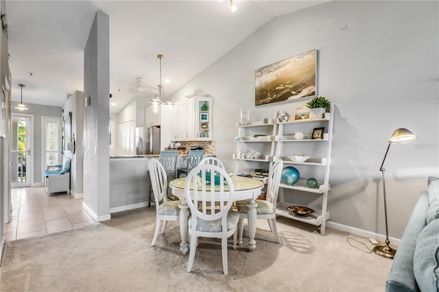 carpeted dining room with lofted ceiling