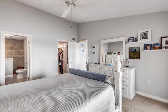 carpeted bedroom featuring ensuite bath, a spacious closet, ceiling fan, lofted ceiling, and a closet