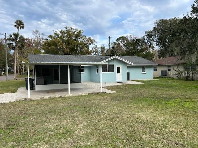 rear view of property with a lawn and a patio