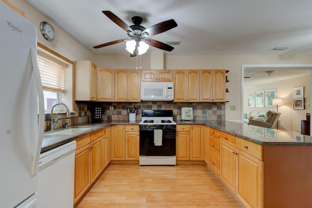 kitchen featuring sink, backsplash, kitchen peninsula, white appliances, and light wood-type flooring