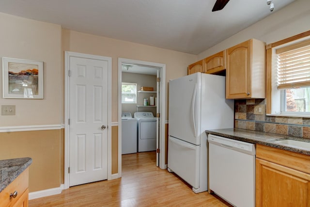 kitchen with washer and clothes dryer, light brown cabinets, white appliances, decorative backsplash, and light hardwood / wood-style floors