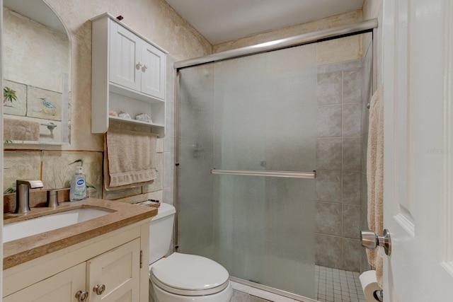 bathroom featuring toilet, vanity, and walk in shower