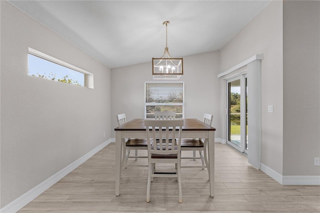 unfurnished dining area featuring a chandelier, light hardwood / wood-style floors, and lofted ceiling