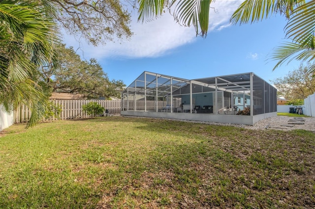 view of yard with glass enclosure and a fenced backyard